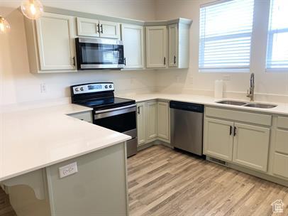 3985 W 1960 N, Lehi, UT 84043 - kitchen with stainless steel appliances, a peninsula, light countertops, light wood-type flooring, and hanging light fixtures