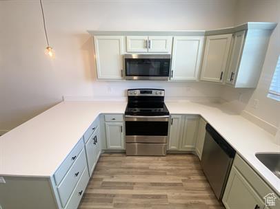 3985 W 1960 N, Lehi, UT 84043 - kitchen featuring appliances with stainless steel finishes, a peninsula, light wood finished floors, light countertops, and hanging light fixtures