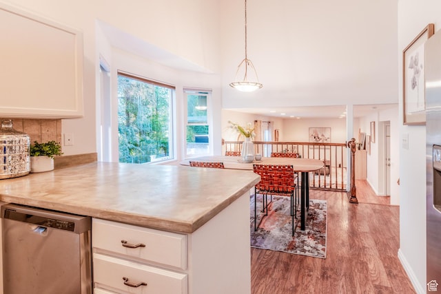1282 W 1200 S, Woods Cross, UT 84087 - kitchen with stainless steel dishwasher, wood finished floors, white cabinetry, a towering ceiling, and light countertops