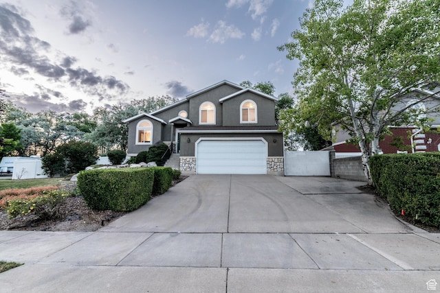 1282 W 1200 S, Woods Cross, UT 84087 - view of front facade with stucco siding, driveway, stone siding, a garage, and a gate