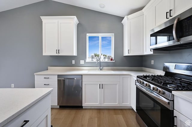 40 S 100 W, Trenton, UT 84338 - kitchen featuring appliances with stainless steel finishes, light wood-style floors, white cabinetry, and vaulted ceiling