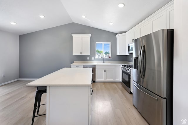 40 S 100 W, Trenton, UT 84338 - kitchen with stainless steel appliances, light wood-style floors, a center island, lofted ceiling, and a breakfast bar