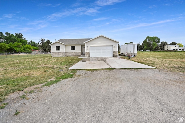 40 S 100 W, Trenton, UT 84338 - ranch-style house with stone siding, driveway, a front lawn, and a garage