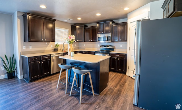 6561 S Evening Glow Ct W, West Jordan, UT 84081 - kitchen with appliances with stainless steel finishes, dark wood-type flooring, light countertops, a center island, and recessed lighting