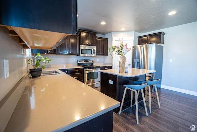 6561 S Evening Glow Ct W, West Jordan, UT 84081 - kitchen featuring stainless steel appliances, dark wood-style floors, a center island, light countertops, and recessed lighting