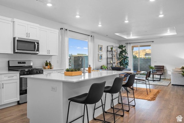 1465 S Staircase Way Unit 4065, Washington, UT 84780 - kitchen featuring appliances with stainless steel finishes, a center island, a kitchen breakfast bar, white cabinets, and recessed lighting