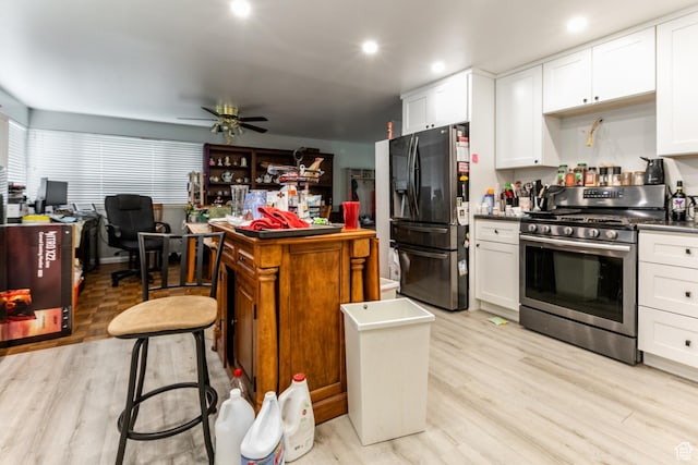 5841 S Fontaine Bleu Dr E, Murray, UT 84121 - kitchen with stainless steel appliances, a desk, light wood-style floors, white cabinetry, and recessed lighting