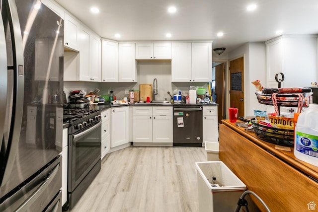 5841 S Fontaine Bleu Dr E, Murray, UT 84121 - kitchen with freestanding refrigerator, dishwasher, range with gas cooktop, light wood-style flooring, and white cabinetry