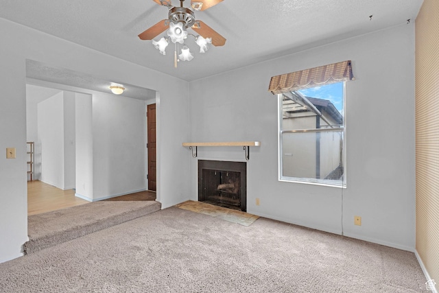597 W Brookshire Dr, Ogden, UT 84405 - unfurnished living room featuring carpet, a fireplace with flush hearth, and ceiling fan