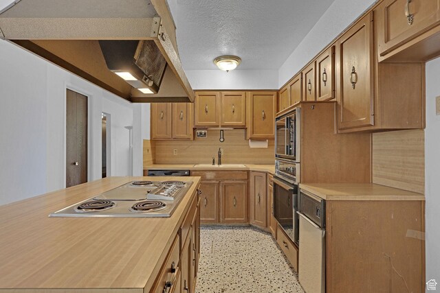 597 W Brookshire Dr, Ogden, UT 84405 - kitchen with appliances with stainless steel finishes, tasteful backsplash, a textured ceiling, brown cabinetry, and butcher block countertops