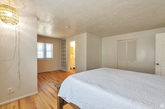 648 E 2550 N, North Ogden, UT 84414 - bedroom with a textured ceiling, light wood finished floors, a closet, and a chandelier