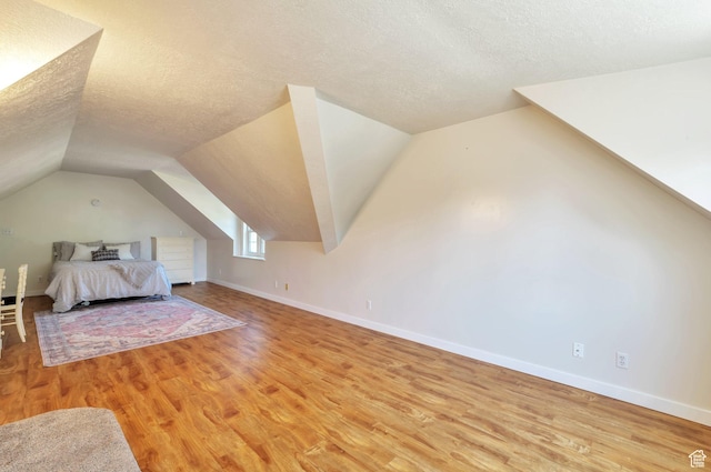 648 E 2550 N, North Ogden, UT 84414 - bedroom featuring a textured ceiling, light wood-style flooring, and vaulted ceiling