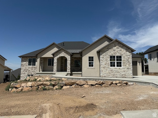 4095 N 100 E, North Ogden, UT 84414 - view of front of home featuring stone siding, a standing seam roof, a garage, concrete driveway, and a metal roof