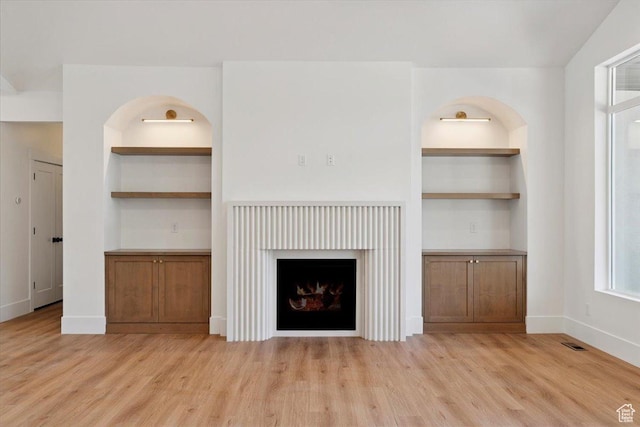 4095 N 100 E, North Ogden, UT 84414 - unfurnished living room featuring built in features, light wood-style floors, and a fireplace