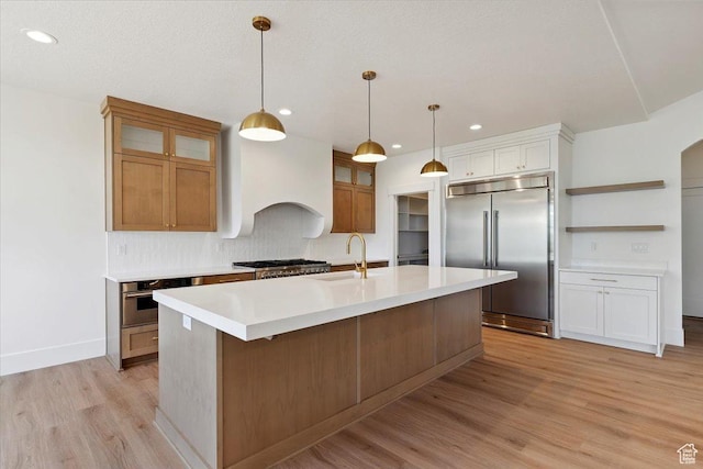 4095 N 100 E, North Ogden, UT 84414 - kitchen featuring appliances with stainless steel finishes, light wood-style flooring, light countertops, a kitchen island with sink, and open shelves