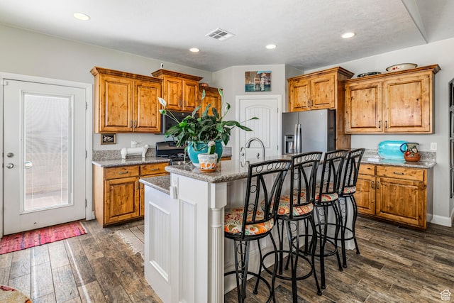 93 E 700 N, La Verkin, UT 84745 - kitchen featuring stainless steel appliances, brown cabinetry, an island with sink, dark wood-type flooring, and recessed lighting