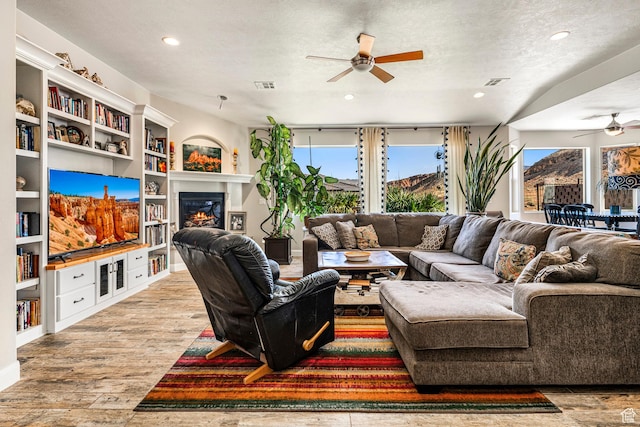 93 E 700 N, La Verkin, UT 84745 - living area featuring ceiling fan, wood finished floors, recessed lighting, a glass covered fireplace, and a textured ceiling