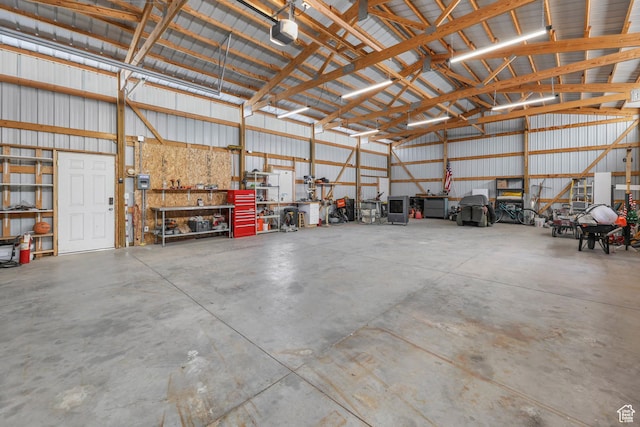 1309 Pine Canyon Rd, Tooele, UT 84074 - garage featuring a garage door opener, metal wall, and a workshop area