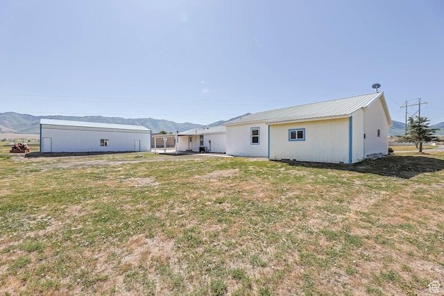 1309 Pine Canyon Rd, Tooele, UT 84074 - back of house featuring a mountain view, a lawn, and a metal roof