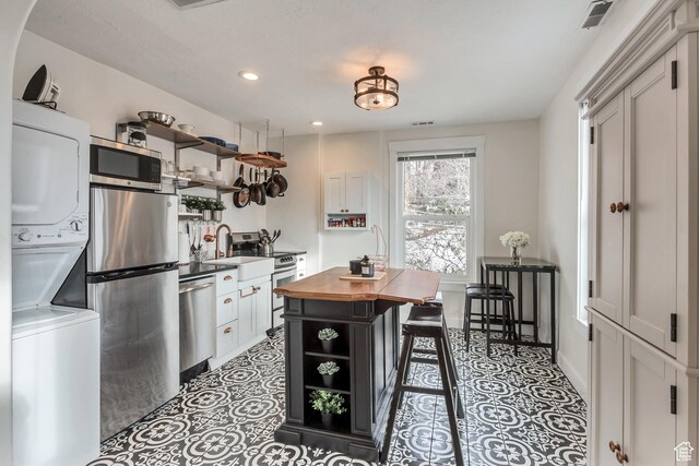 22 W 300 N, Salt Lake City, UT 84103 - kitchen featuring open shelves, stacked washer and clothes dryer, appliances with stainless steel finishes, butcher block countertops, and recessed lighting