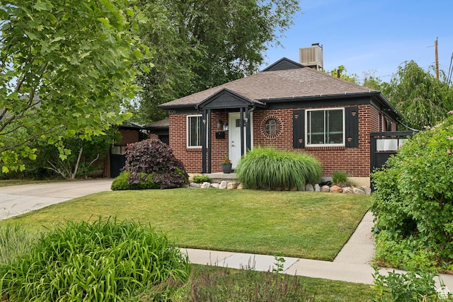 1026 W 800 N, Salt Lake City, UT 84116 - bungalow-style house featuring brick siding, a front lawn, a chimney, driveway, and roof with shingles