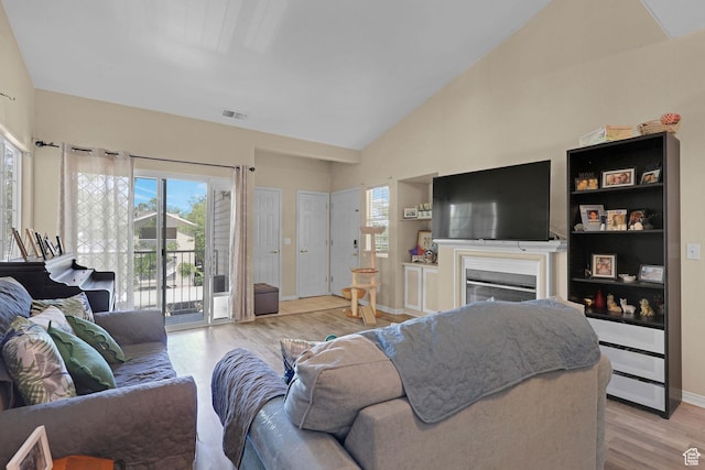 3827 S Big River Way W Unit 3, South Salt Lake, UT 84119 - living room with plenty of natural light, light wood-style flooring, a glass covered fireplace, and high vaulted ceiling