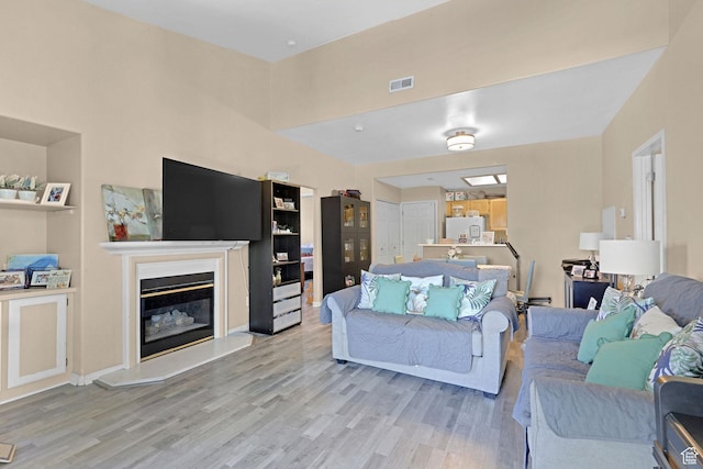3827 S Big River Way W Unit 3, South Salt Lake, UT 84119 - living room featuring light wood-style flooring and a glass covered fireplace