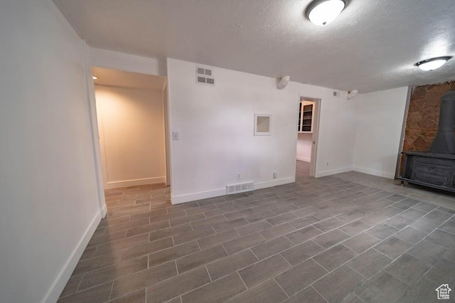 195 N 800 W, Cleveland, UT 84518 - unfurnished living room with a wood stove and a textured ceiling