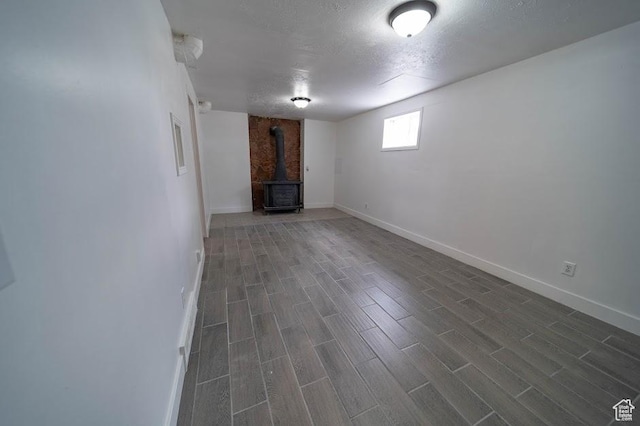 195 N 800 W, Cleveland, UT 84518 - basement featuring a wood stove, dark wood-type flooring, and a textured ceiling