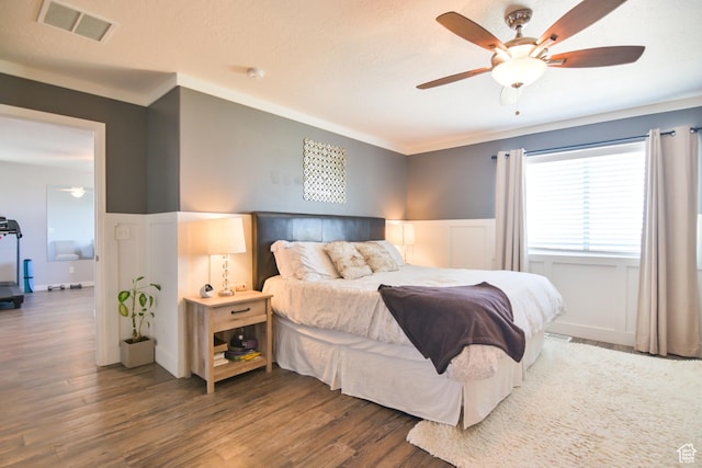 3319 N Falcon Way, Layton, UT 84040 - bedroom featuring wainscoting, wood finished floors, a decorative wall, crown molding, and ceiling fan
