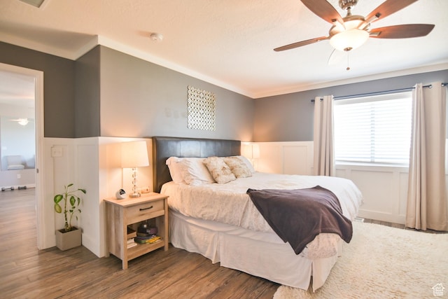 3319 N Falcon Way, Layton, UT 84040 - bedroom with a wainscoted wall, ornamental molding, wood finished floors, a ceiling fan, and a decorative wall