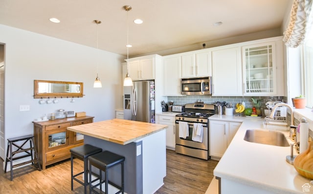 3319 N Falcon Way, Layton, UT 84040 - kitchen with appliances with stainless steel finishes, a kitchen bar, tasteful backsplash, wooden counters, and wood finished floors