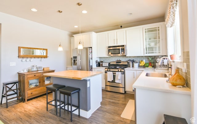 3319 N Falcon Way, Layton, UT 84040 - kitchen featuring appliances with stainless steel finishes, a kitchen bar, tasteful backsplash, a center island, and pendant lighting