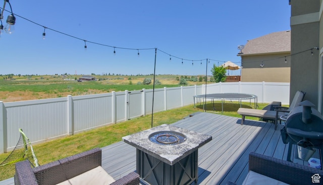 3319 N Falcon Way, Layton, UT 84040 - deck featuring a trampoline, a fenced backyard, a fire pit, and area for grilling