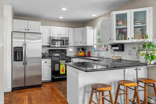 44 S 1000 E, Springville, UT 84663 - kitchen featuring appliances with stainless steel finishes, dark countertops, a peninsula, dark wood-type flooring, and white cabinetry