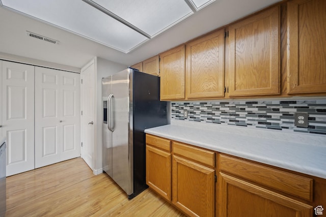 3807 S River Run Way Unit 3, Salt Lake City, UT 84119 - kitchen featuring stainless steel refrigerator with ice dispenser, light wood-style flooring, light countertops, tasteful backsplash, and brown cabinets