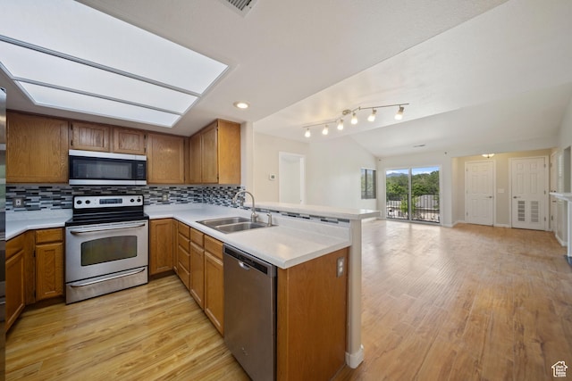 3807 S River Run Way Unit 3, Salt Lake City, UT 84119 - kitchen featuring stainless steel appliances, a peninsula, open floor plan, light wood-type flooring, and light countertops