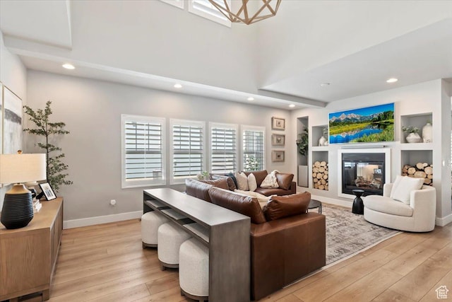 5057 W Bowstring Way S, South Jordan, UT 84009 - living area with light wood-type flooring, recessed lighting, built in features, and a glass covered fireplace