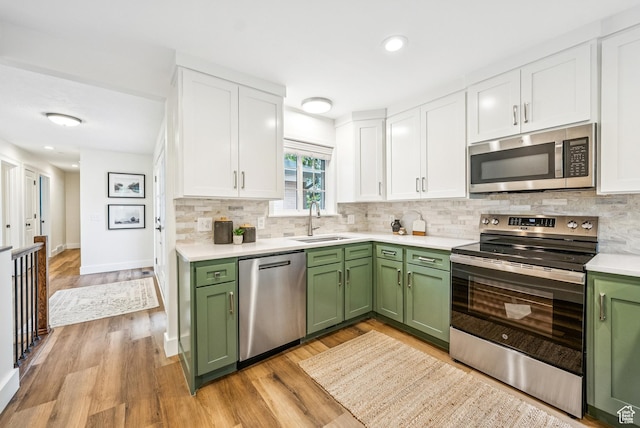 8816 S Alpen Way E, Cottonwood Heights, UT 84121 - kitchen with green cabinets, stainless steel appliances, white cabinets, light countertops, and decorative backsplash