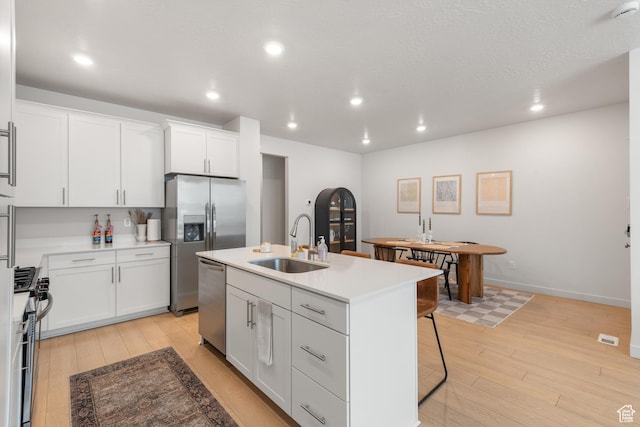 938 W Terracotta Dr, Saratoga Springs, UT 84045 - kitchen featuring stainless steel appliances, light wood-style floors, a kitchen island with sink, white cabinets, and recessed lighting