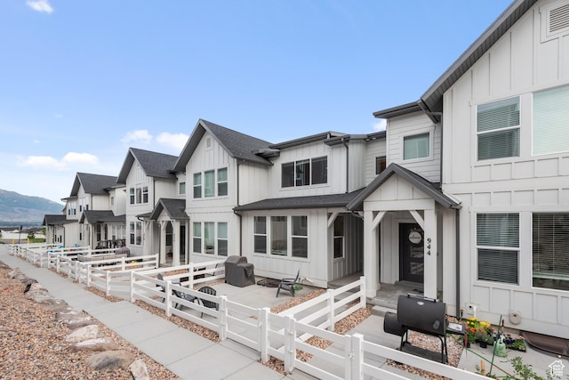 938 W Terracotta Dr, Saratoga Springs, UT 84045 - back of house with board and batten siding, a fenced front yard, a mountain view, and a gate