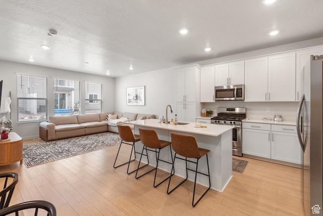 938 W Terracotta Dr, Saratoga Springs, UT 84045 - kitchen featuring stainless steel appliances, a breakfast bar, open floor plan, recessed lighting, and a center island with sink