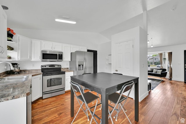 874 W 1145 N, Clinton, UT 84015 - kitchen with appliances with stainless steel finishes, vaulted ceiling, open shelves, white cabinets, and light wood finished floors