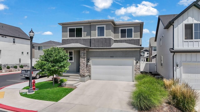 1666 W Rockaway Ln, West Jordan, UT 84084 - view of front of home featuring board and batten siding, a garage, stone siding, driveway, and stucco siding