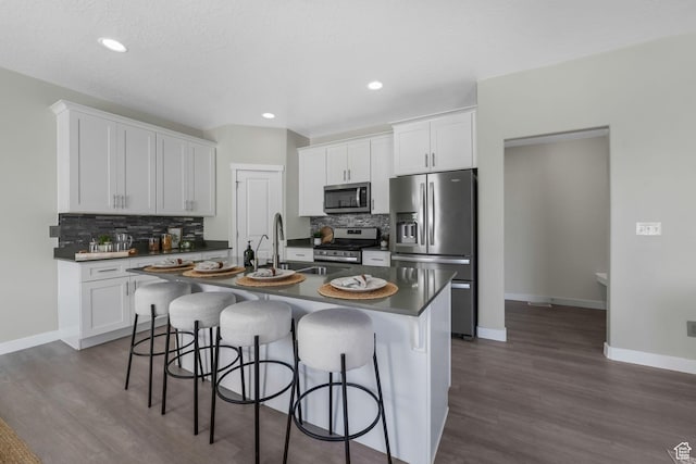 1666 W Rockaway Ln, West Jordan, UT 84084 - kitchen featuring appliances with stainless steel finishes, dark countertops, backsplash, dark wood-style floors, and recessed lighting