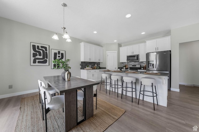 1666 W Rockaway Ln, West Jordan, UT 84084 - dining room featuring wood finished floors, a chandelier, and recessed lighting