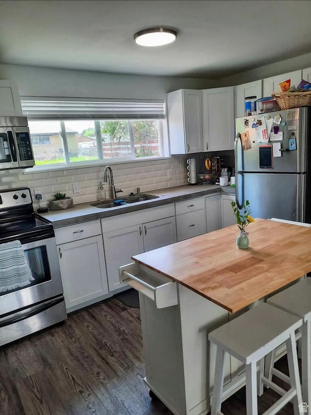 1018 E 40 N, Springville, UT 84663 - kitchen featuring appliances with stainless steel finishes, decorative backsplash, white cabinetry, dark wood-type flooring, and butcher block counters