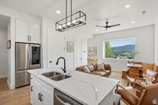 3547 N Creekside Way, Eden, UT 84310 - kitchen with stainless steel appliances, open floor plan, white cabinetry, light wood-style floors, and recessed lighting