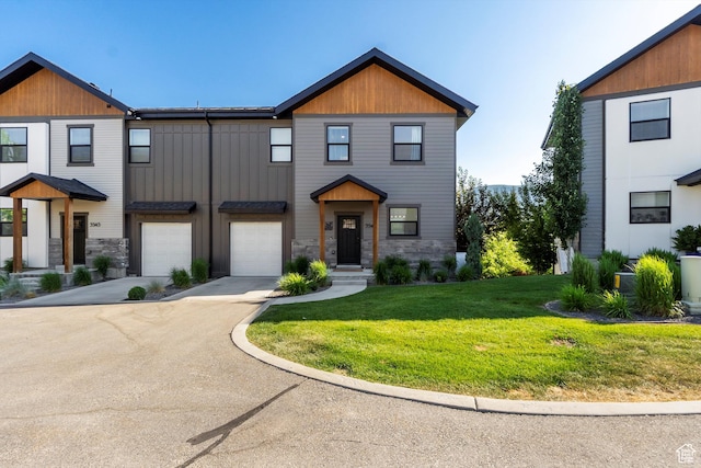 3547 N Creekside Way, Eden, UT 84310 - view of front of house featuring driveway, a front yard, an attached garage, and stone siding
