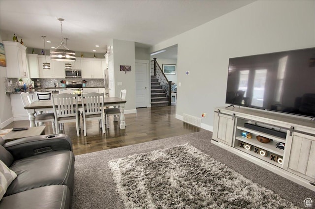 342 E Chiswick Ct, Stansbury Park, UT 84074 - living room featuring stairway and dark wood-type flooring